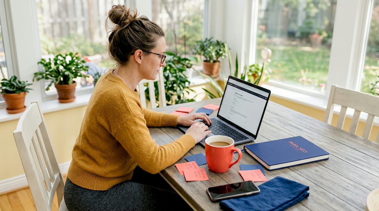 1779071622712_Business-owner-updating-profile-at-kitchen-table Business owner updating profile at kitchen table
